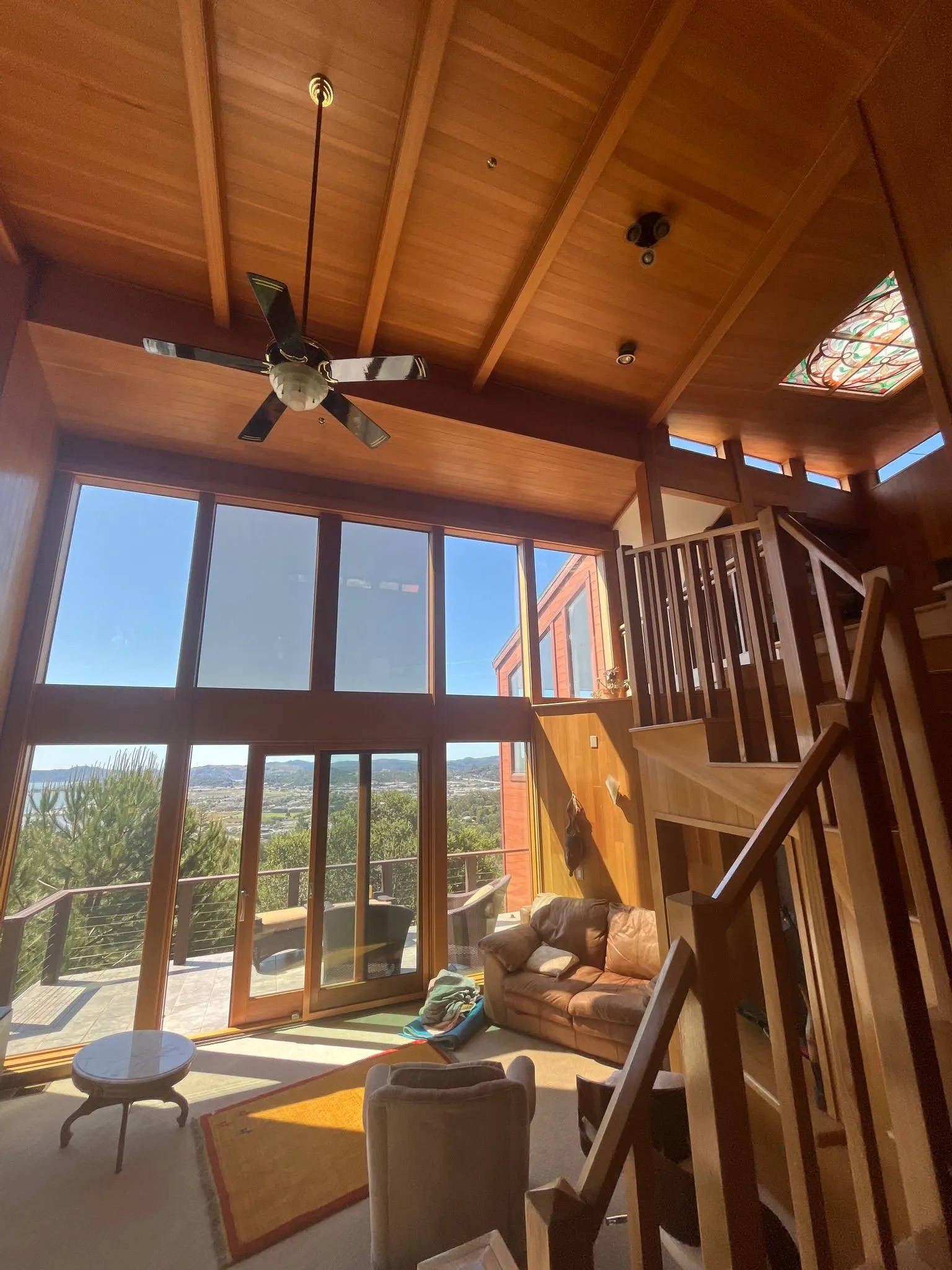 A great room with a vaulted fir ceiling and floor-to-ceiling windows over the valley